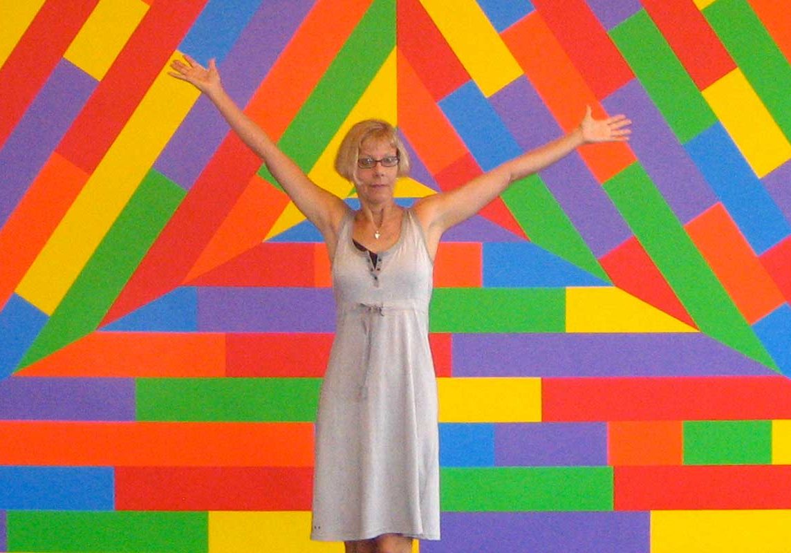 photo of louise in front of colorful artwork.